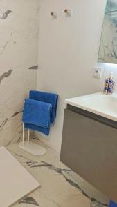 um banheiro com uma pia e uma toalha azul em um banquinho em Blanche-Neige CLIM Ile Verte proche Hôpital em Grenoble