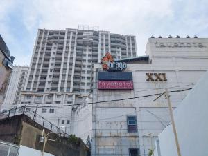 a tall white building with a sign in front of it at Tranquil Designed 2BR at Braga City Walk Apartment By Travelio in Bandung
