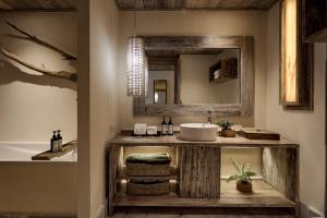 芭东海滩Dinso Resort & Villas Phuket, Vignette Collection by IHG的带水槽和镜子的浴室