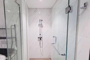 a shower with a glass door in a bathroom at 1BR Premium Branz BSD Apartment by OWARI in Samporo +14 photos
