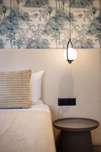 a bedroom with a bed with a table and a wallpaper at Villa Frantzeska - Elegant Villa close to Tsilivi, by ZanteWize in Tsilivi
