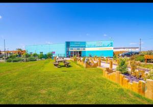 a building with a picnic table and benches in a field at MP502 - Camber Sands Holiday Park - Sleeps 6 - Small Dog - Gated Decking - Amazing Marsh Views in Camber