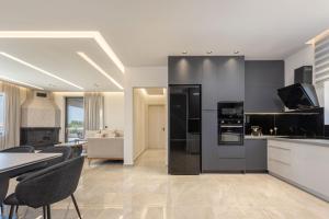 a kitchen with black appliances and a table and chairs at Villa Frantzeska - Elegant Villa close to Tsilivi, by ZanteWize in Tsilivi +49 photos
