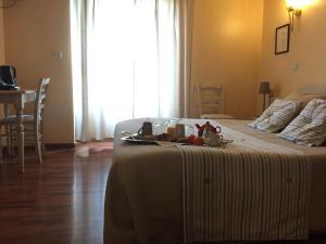 a bedroom with a bed with a tray of food on it at Logis Hôtel Les 3B in Nouilhan