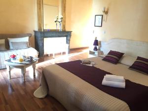 a bedroom with a large bed and a couch at Logis Hôtel Les 3B in Nouilhan