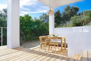a patio with a table and chairs on a deck at Villa Gianna Maria in Paleros