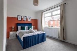 a bedroom with a blue bed and a window at Stylish 3-br Home In Gateshead Near Newcastle in Gateshead