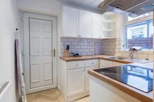 a kitchen with white cabinets and a sink at Stylish 3-br Home In Gateshead Near Newcastle in Gateshead