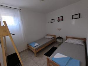 a small room with two beds and a window at Stella in Novi Vinodolski