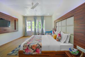 a bedroom with a large bed and a tv at Pax Hotel Rock Villa Swimming Pool Available Dalhousie in Dalhousie