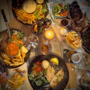 a table topped with plates of food and french fries at B&B de Muldermolen in Schinnen