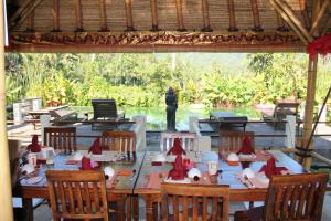 - une salle à manger avec une table et des chapeaux rouges dans l'établissement Villa Manuk, à Singaraja