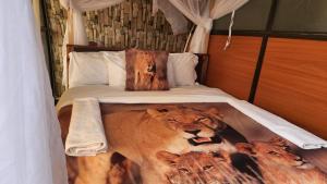 een slaapkamer met een bed met twee leeuwen erop bij Little Amanya Camp in Amboseli