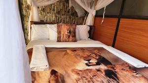 een slaapkamer met een bed met twee leeuwen erop bij Little Amanya Camp in Amboseli