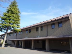 a building with a tree in front of it at Breezbay Seaside Resort Matsushima in Matsushima