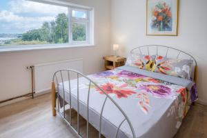 une chambre avec un lit et une fenêtre dans l'établissement Longview - 4 Bedroom Holiday Home - Pembroke Dock, à Pembroke Dock