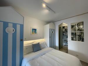 a bedroom with a large white bed with blue accents at Ocean Balcony apartment terrace sea view and pool in Albufeira