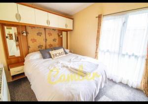 a bedroom with a large bed and a window at MP503 - Camber Sands Holiday Park - Sleeps 8 - Large Gated Decking - Amazing views in Camber