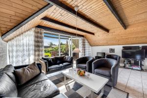 a living room with leather furniture and a table at Just 500 Meters From Both The Sea And The Town, This Lovely, Well-Maintained Holiday Home Is Situated in Ringkøbing +22 photos