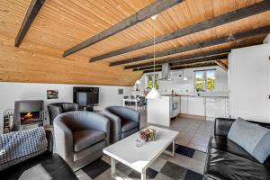 a living room with couches and a table and a kitchen at Just 500 Meters From Both The Sea And The Town, This Lovely, Well-Maintained Holiday Home Is Situated in Ringkøbing