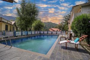 a large swimming pool with a bench next to a building at Pax Hotel Rock Villa Swimming Pool Available Dalhousie in Dalhousie