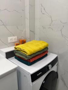 a stack of towels sitting on top of a washing machine at PARIS-MONTROUGE Magnifique appartement 3 pièces de 78m2 avec PARKING - très cosy pour 1 - 6 personnes refait à NEUF -ENTIRE APARTMENT LUXURIOUS AND WARM -Montrouge Paris 14ème - Proche Aéroport Orly Parc Expositions Porte de Versailles FREE WIFI GRATUIT in Montrouge +39 photos