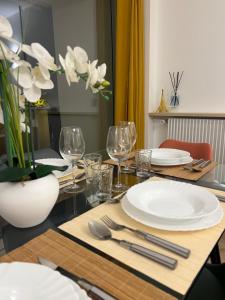 a dining table with white plates and silverware on it at PARIS-MONTROUGE Magnifique appartement 3 pièces de 78m2 avec PARKING - très cosy pour 1 - 6 personnes refait à NEUF -ENTIRE APARTMENT LUXURIOUS AND WARM -Montrouge Paris 14ème - Proche Aéroport Orly Parc Expositions Porte de Versailles FREE WIFI GRATUIT in Montrouge