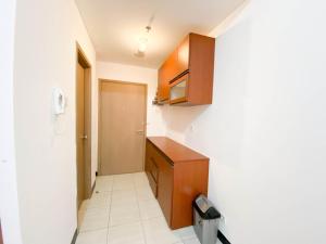 a small kitchen with a wooden cabinet and a door at Cozy Stay Studio Cordova Edupartment Semarang Apartment By Travelio in Semarang