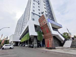 a tall white building with a sign on it at Cozy Stay Studio Cordova Edupartment Semarang Apartment By Travelio in Semarang