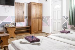 two beds in a room with purple towels on them at Air&Day in Vecsés