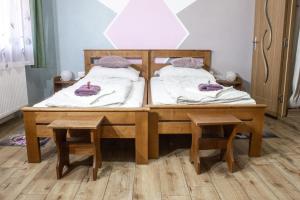 a wooden bed with two stools in a room at Air&Day in Vecsés
