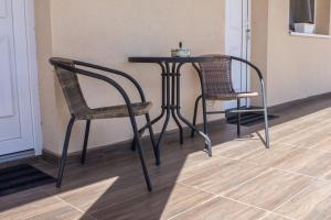 two chairs and a table in a room with a table at Air&Day in Vecsés