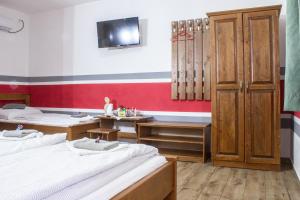 a room with two beds and a tv on the wall at Air&Day in Vecsés