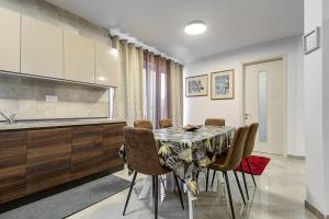 ein Esszimmer mit einem Tisch und einigen Stühlen in der Unterkunft Cosy 3BR Home with Backyard in central of Gzira by 360 Estates in Gżira