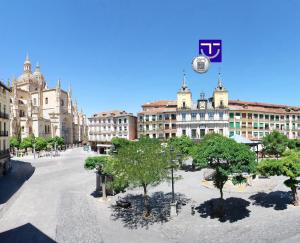 a city square with trees in front of a building at Hotel Infanta Isabel by Recordis Hotels in Segovia