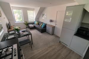 a kitchen and living room with a couch and a table at Beautiful town centre apartment in Huntingdon +17 photos