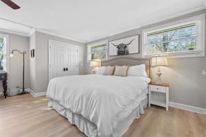 Un dormitorio blanco con una cama grande y dos ventanas. en The Country Cottage of Franklin, TN, en Franklin