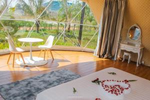 a room with a table and chairs and a large window at Thisak Resort Cheung phnom kulen in Siem Reap