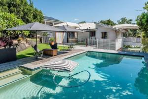 a swimming pool with a bed and an umbrella at The Backyard Oasis Bardon Pool, Games Room in Brisbane