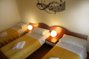 a bedroom with two beds and a chandelier at B&B Music in Milan