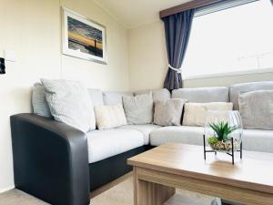 a living room with a couch and a table at Barn Owl Lodge in Bridlington +81 photos
