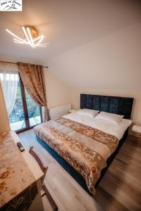 a bedroom with a large bed and a window at Casa Plai cu Soare in Vatra Dornei