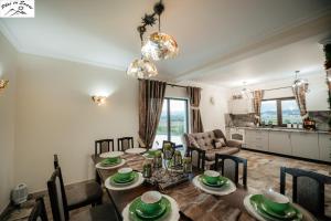 a dining room and living room with a table and chairs at Casa Plai cu Soare in Vatra Dornei
