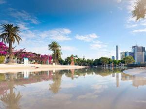 un cuerpo de agua con palmeras y una ciudad en Stylish City Getaway with Pool Gym Parking, en Brisbane