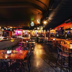 Un restaurante con mesas y sillas y un bar. en Stylish City Getaway with Pool Gym Parking, en Brisbane