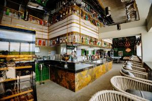 a bar in a restaurant with chairs and bottles at Badsbrotel Suites in Ipil