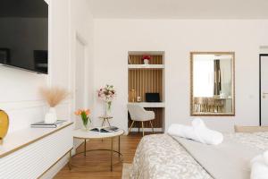 a white bedroom with a bed and a mirror at La Suite del Centro in Varese
