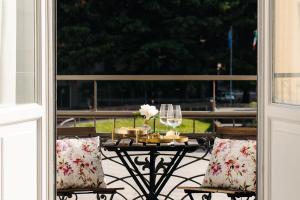 a table with a glass of wine on a balcony at La Suite del Centro in Varese +50 photos