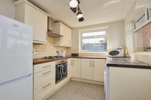 a kitchen with white appliances and a window at Lovely 4-Bedroom House in Hartlepool - Street Parking in Hartlepool