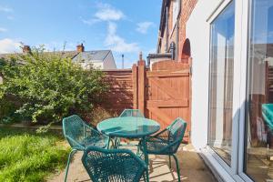 a patio with a table and chairs and a fence at Lovely 4-Bedroom House in Hartlepool - Street Parking in Hartlepool
